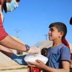 Giving food to a refugee kid