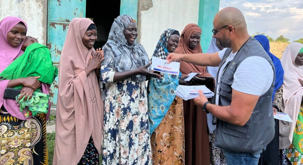 Uomo distribuisce buste Zakat a donne in Africa.
