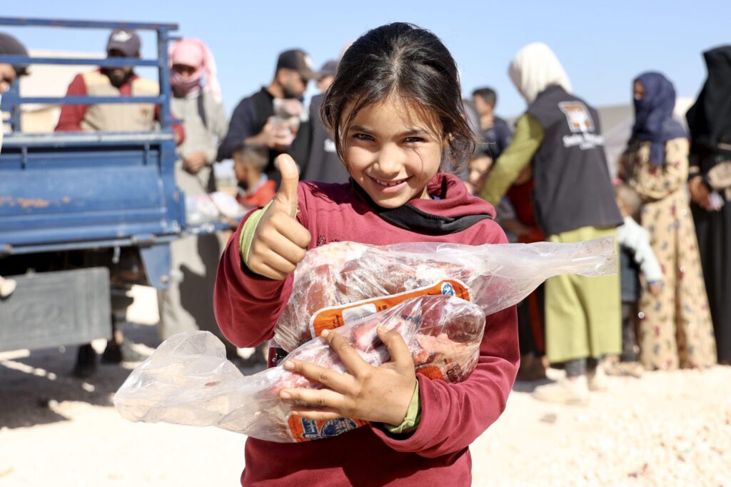 Kind hält eine Kurban‑Spende