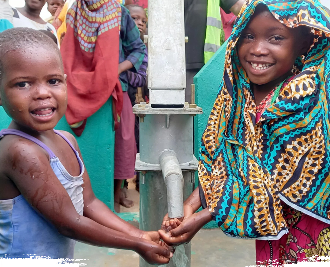 Bambini in un villaggio africano che bevono da un pozzo