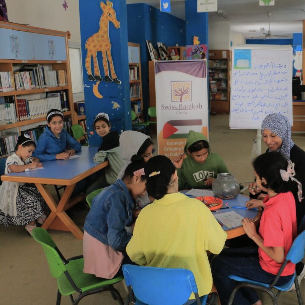 Eine Lehrerin unterstützt Kinder im Unterricht der Barakah Charity. Ihre Spenden für Gaza helfen vor Ort.