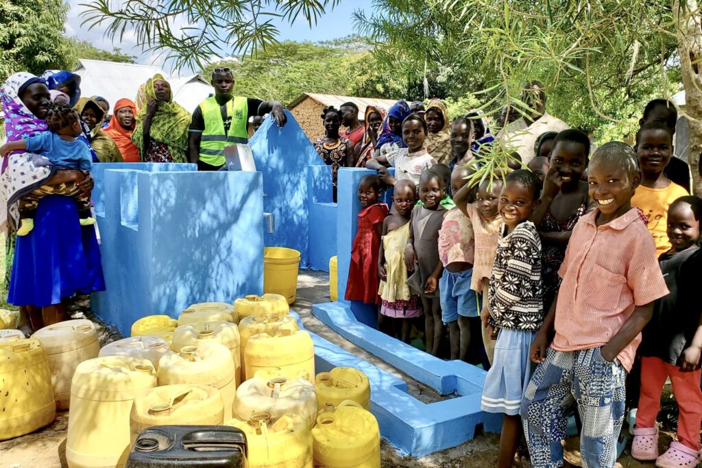 Einwohner in afrikanischen Dörfern bei der Einweihung von Brunnen
